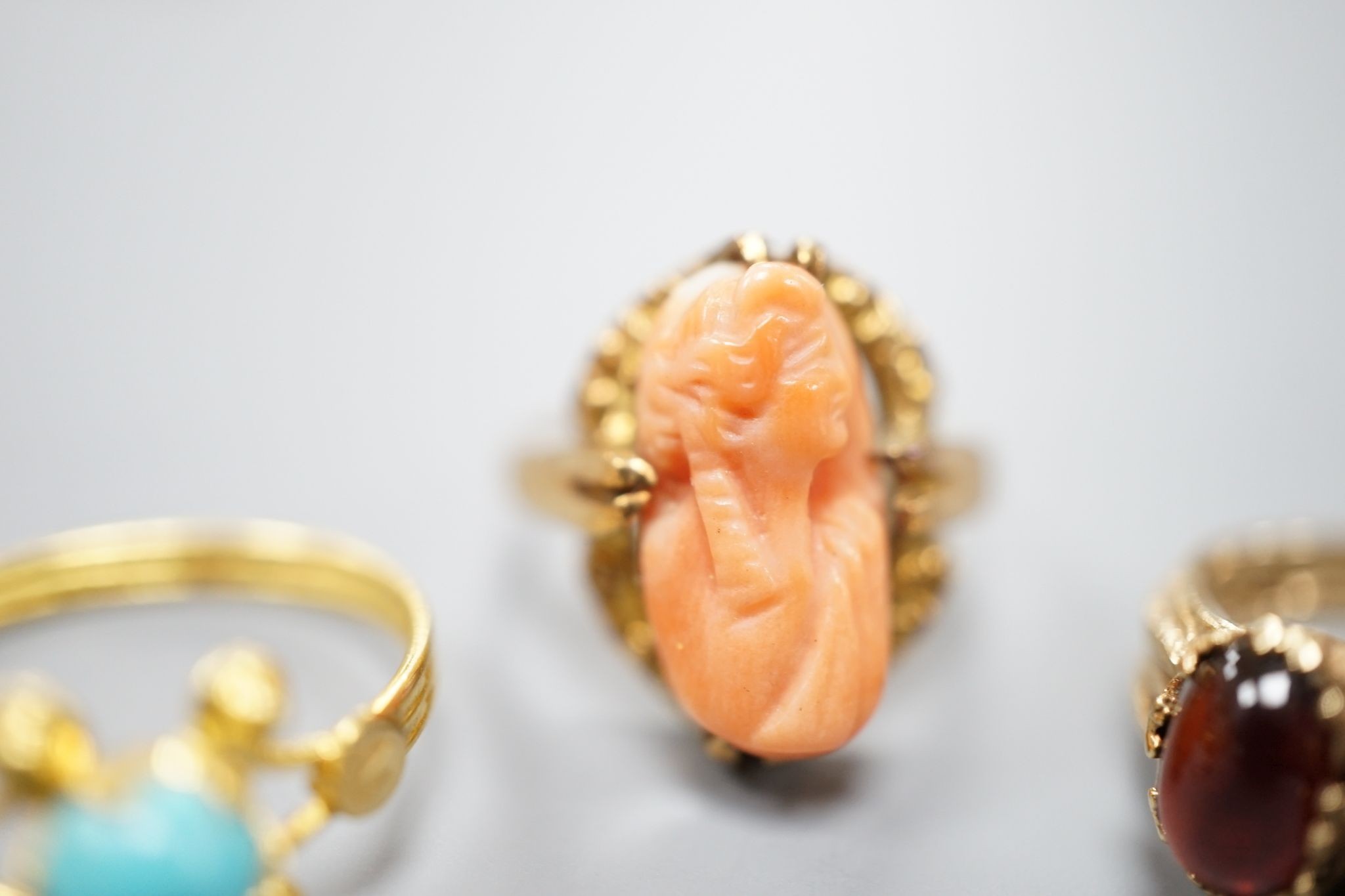 Three assorted modern 9ct gold and gem set ring including turquoise and seed pearl, gross 11.2 grams, a 10k and coral set ring, gross 2.7 grams and a yellow metal and turquoise set ring, gross 1.3 grams.